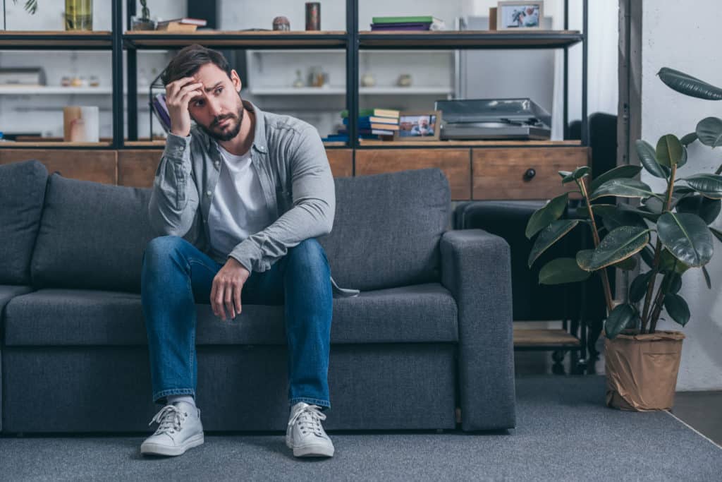 depressed man sitting on couch