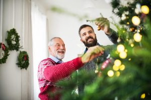 son and father decorating christmas tree