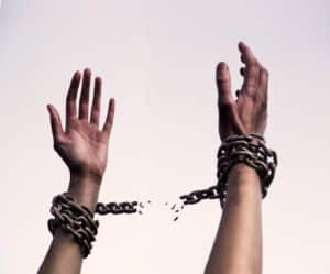hands breaking free of chains