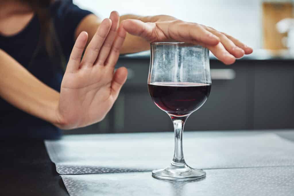 woman declining a glass of wine to maintain sobriety The Bluffs Addiction Campuses