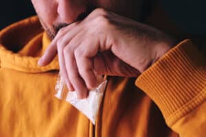 Addict with drug bag in hand